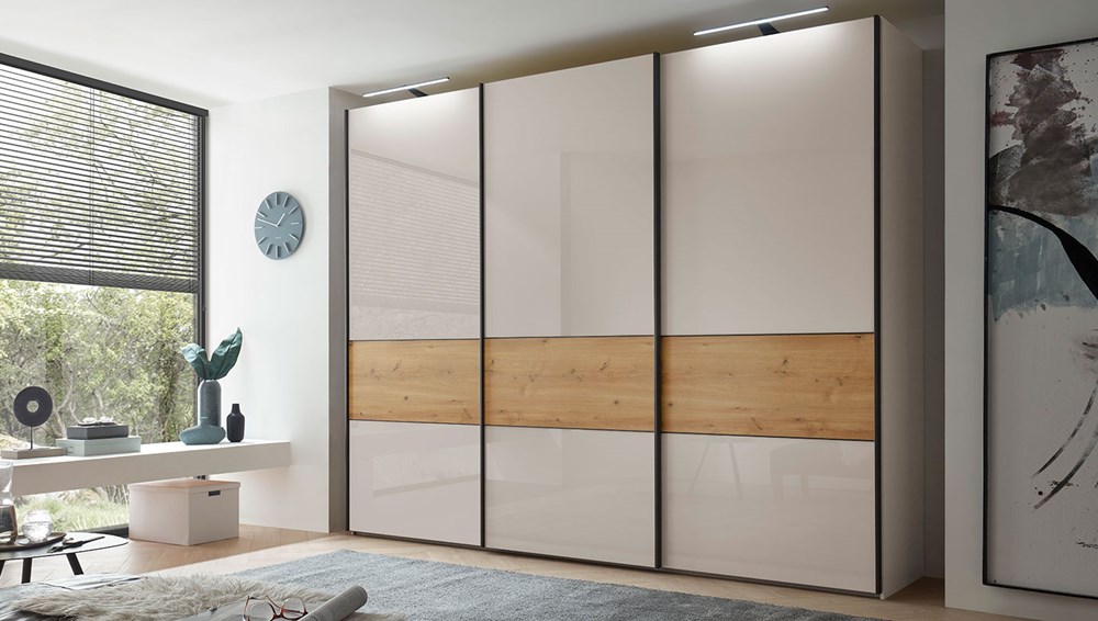 Shown in Champagne with Champagne glass doors and a Bianco Oak cross trim, 300 cm (3 doors) x 236 cm, with LED top lights (no passepartout frame), Slate handles.